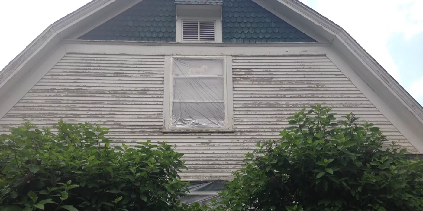 Weathered residential siding before exterior painting